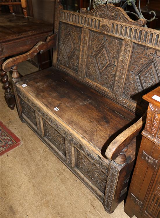 Late Victorian carved oak box seat settle, with scroll arms